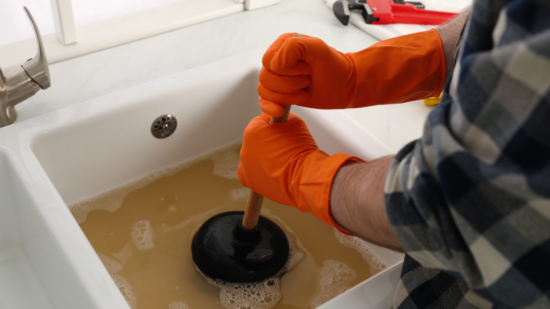 Plombier professionnel effectuant un débouchage de canalisation
